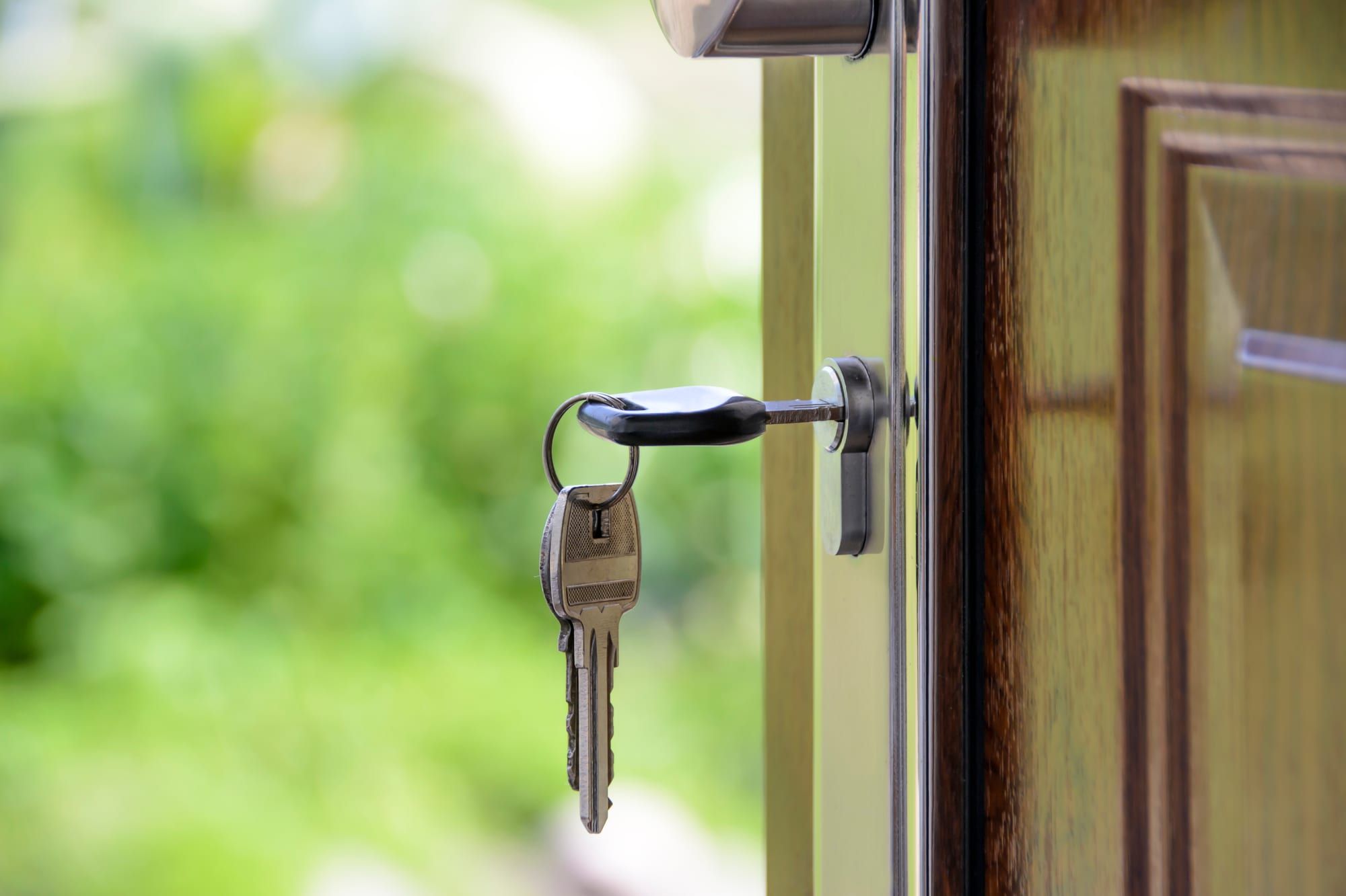 A house key with a key ring left in an open front door