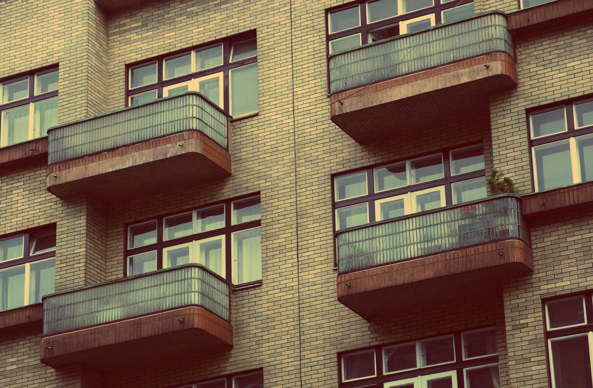 Rows of apartment balconies on a brick building