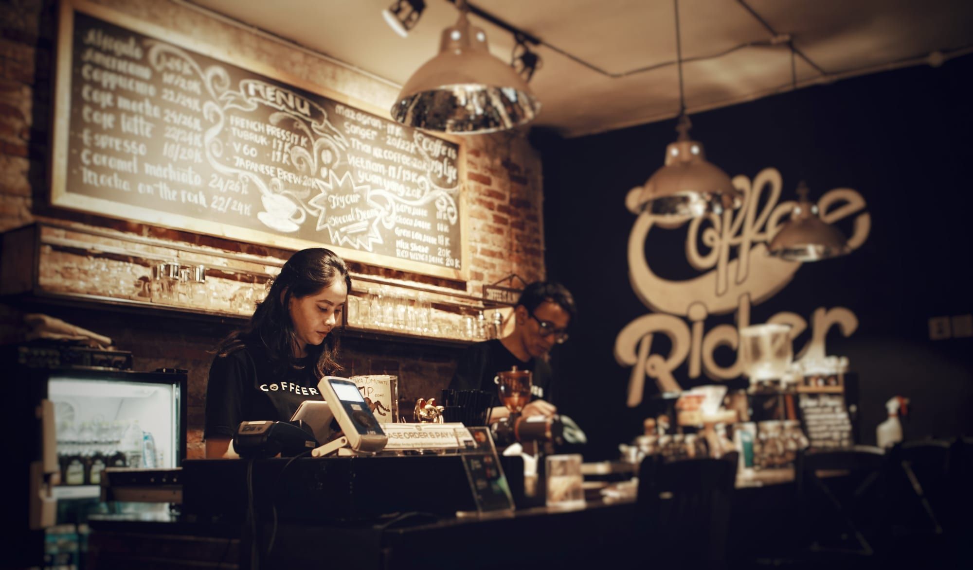 Owners working behind the counter of a small coffee shop