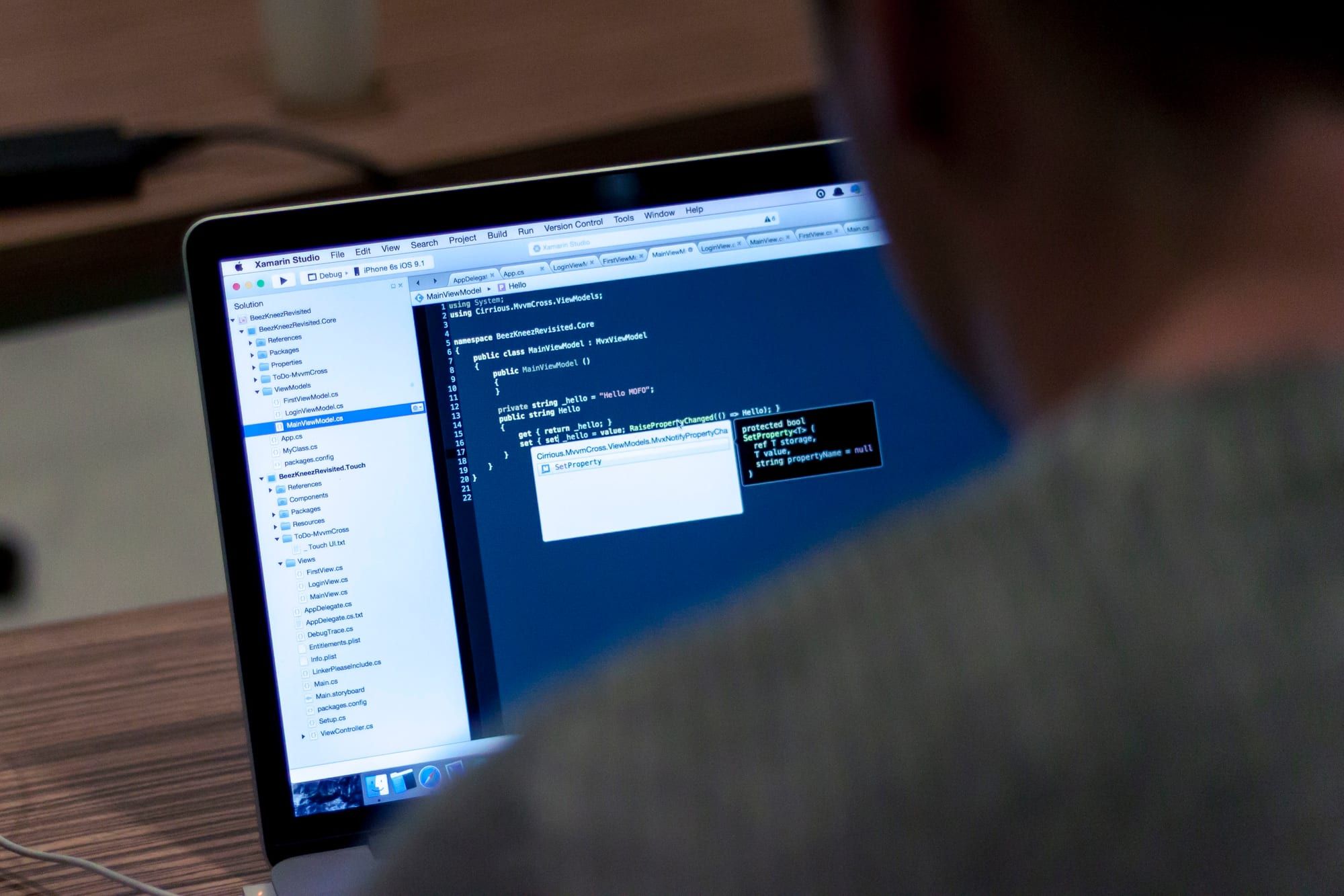 Over-the-shoulder view of a person working in a code editor on a laptop
